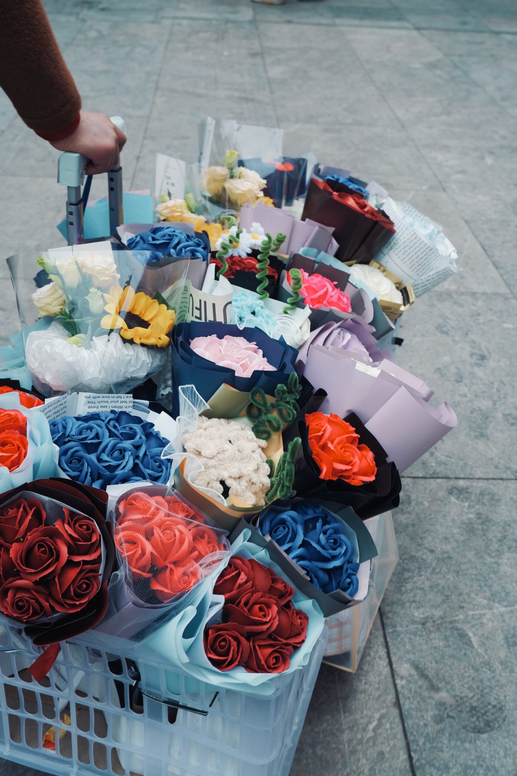 A vibrant array of colorful flower bouquets displayed outdoors on a cart.